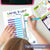 Child's hands filling out a savings tracker with a pen on a white surface, with a digital download label at the bottom.