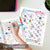 Colorful '31 Days of Gratitude' worksheets on a table with a hand holding a pen.